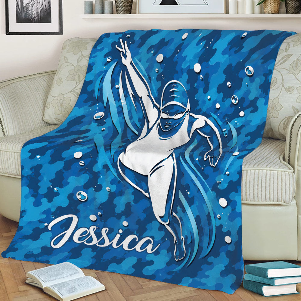 Blue swimmer throw blanket draped across a couch with energetic aquatic artwork