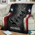 Fishing throw blanket displayed on a sofa with a bold hook and lure illustration and patriotic color accents