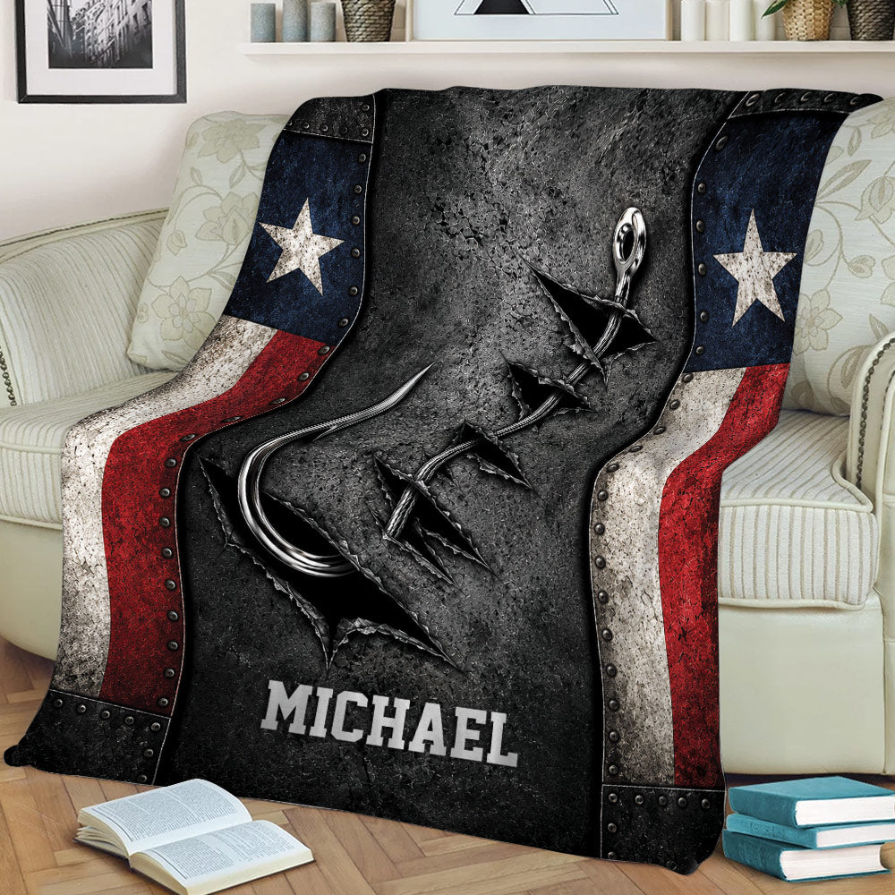 Fishing throw blanket displayed on a sofa with a bold hook and lure illustration and patriotic color accents