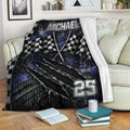 Racing blanket draped over a sofa with checkered flags and rugged tire-track graphics