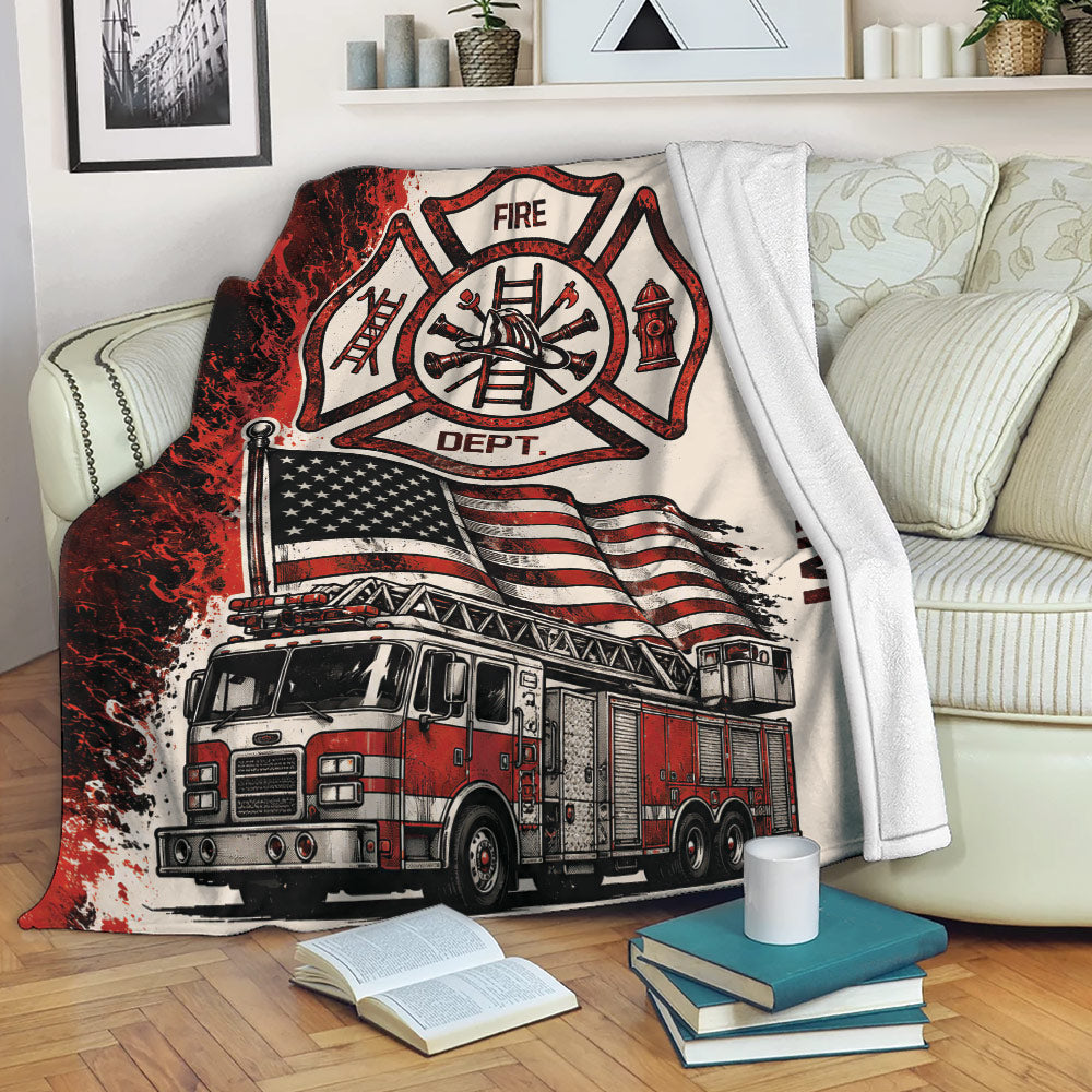 Firefighter blanket displayed on a sofa with a fire department emblem, fire truck, and American flag design