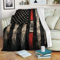 Firefighter blanket draped over a sofa, featuring rugged black, red, and distressed flag artwork