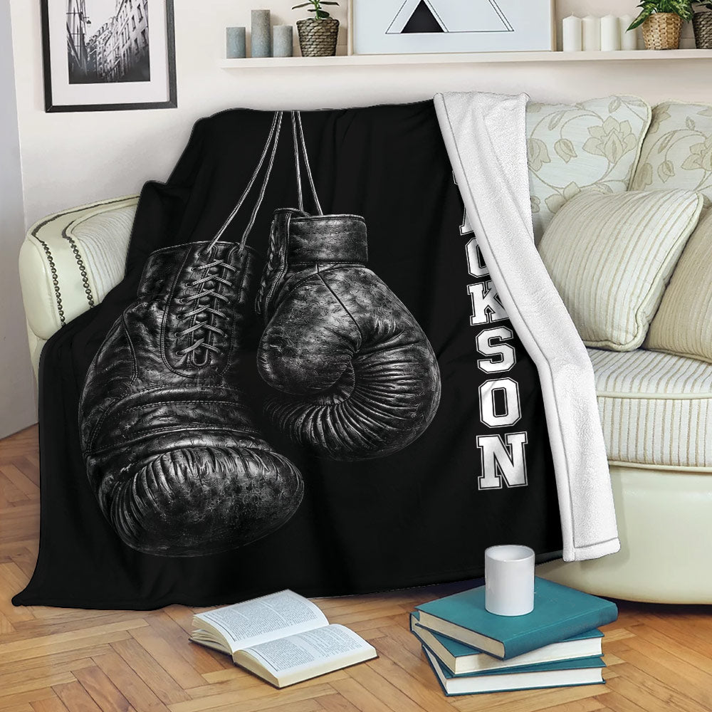 Boxing throw blanket draped over a sofa with black boxing glove artwork in a cozy living room