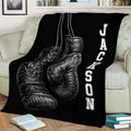 Black boxing blanket displayed on a couch with oversized realistic boxing gloves and monochrome styling