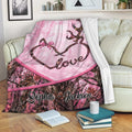 Custom deer blanket draped over a sofa with pink camouflage forest artwork and antler heart design