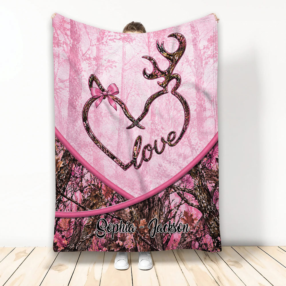 Pink deer throw blanket featuring antler artwork, a heart motif, bow detail, and camouflage forest print
