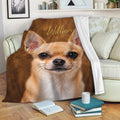 Chihuahua blanket draped over a sofa, featuring a close-up tan dog portrait in cozy living room decor