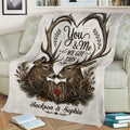 Close view of a rustic deer blanket with antlers, pine branches, and a heart motif