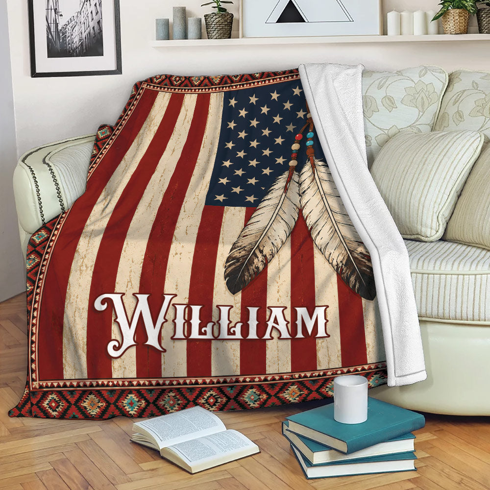 American Native blanket displayed on a sofa with flag stripes, stars, feathers, and decorative border