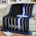 Thin blue line police blanket draped over a couch with distressed flag stripes and blue cross design