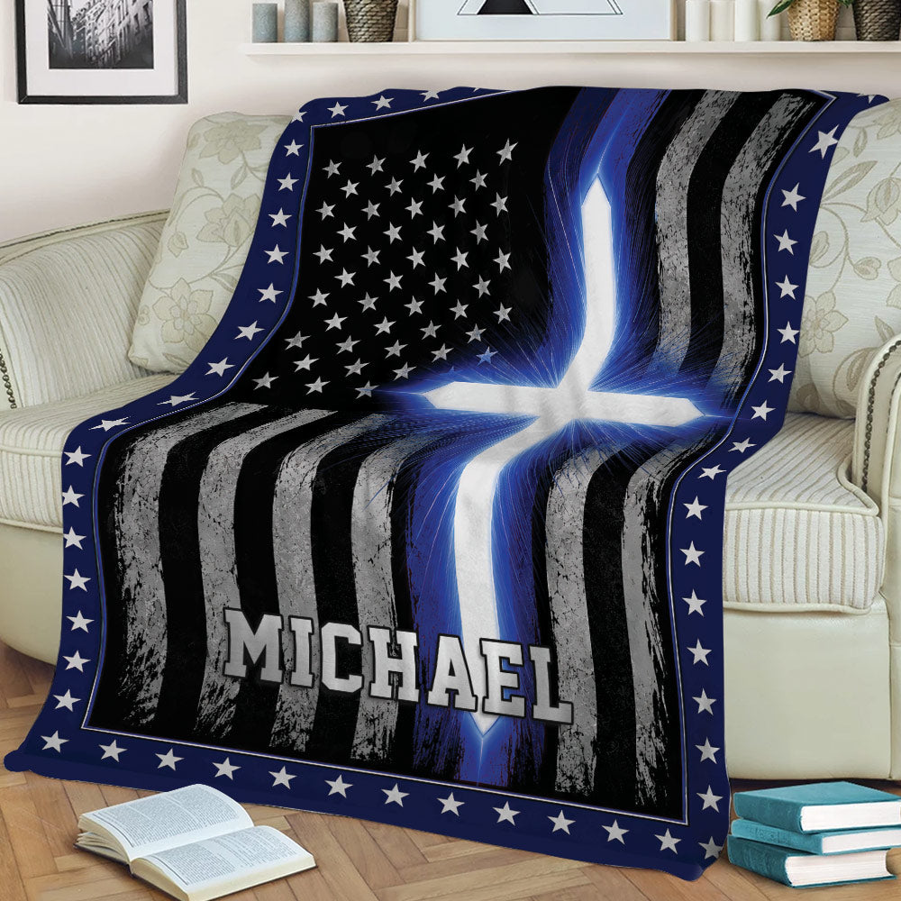 Thin blue line police blanket draped over a couch with distressed flag stripes and blue cross design
