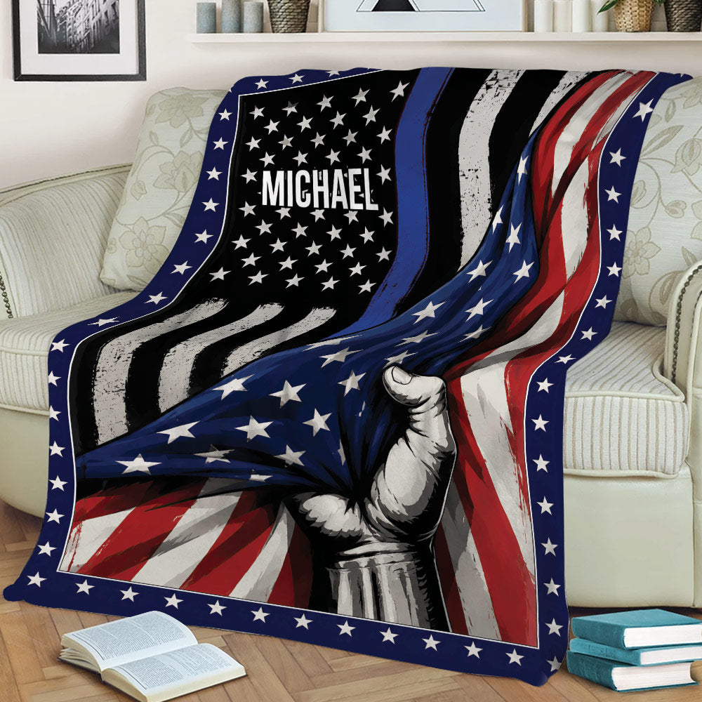 Custom police throw blanket draped over a couch with stars, thin blue line, and patriotic flag artwork