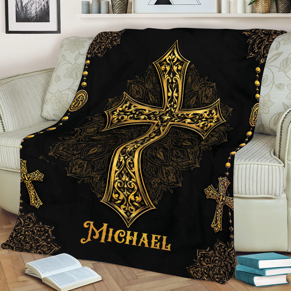 Black and gold Christian throw blanket displayed on a sofa with an ornate cross design