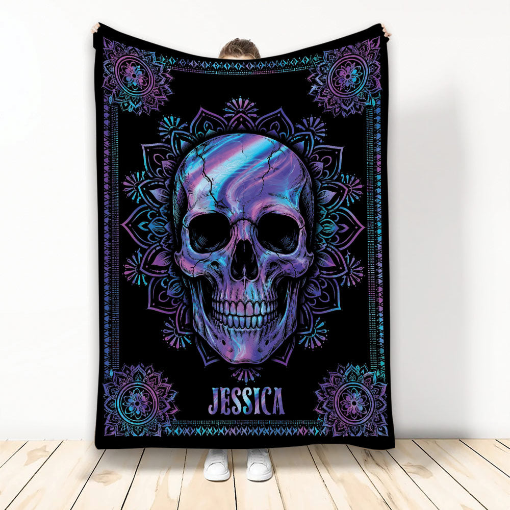 Colorful purple and blue skull blanket with mandala border displayed against a bright room backdrop