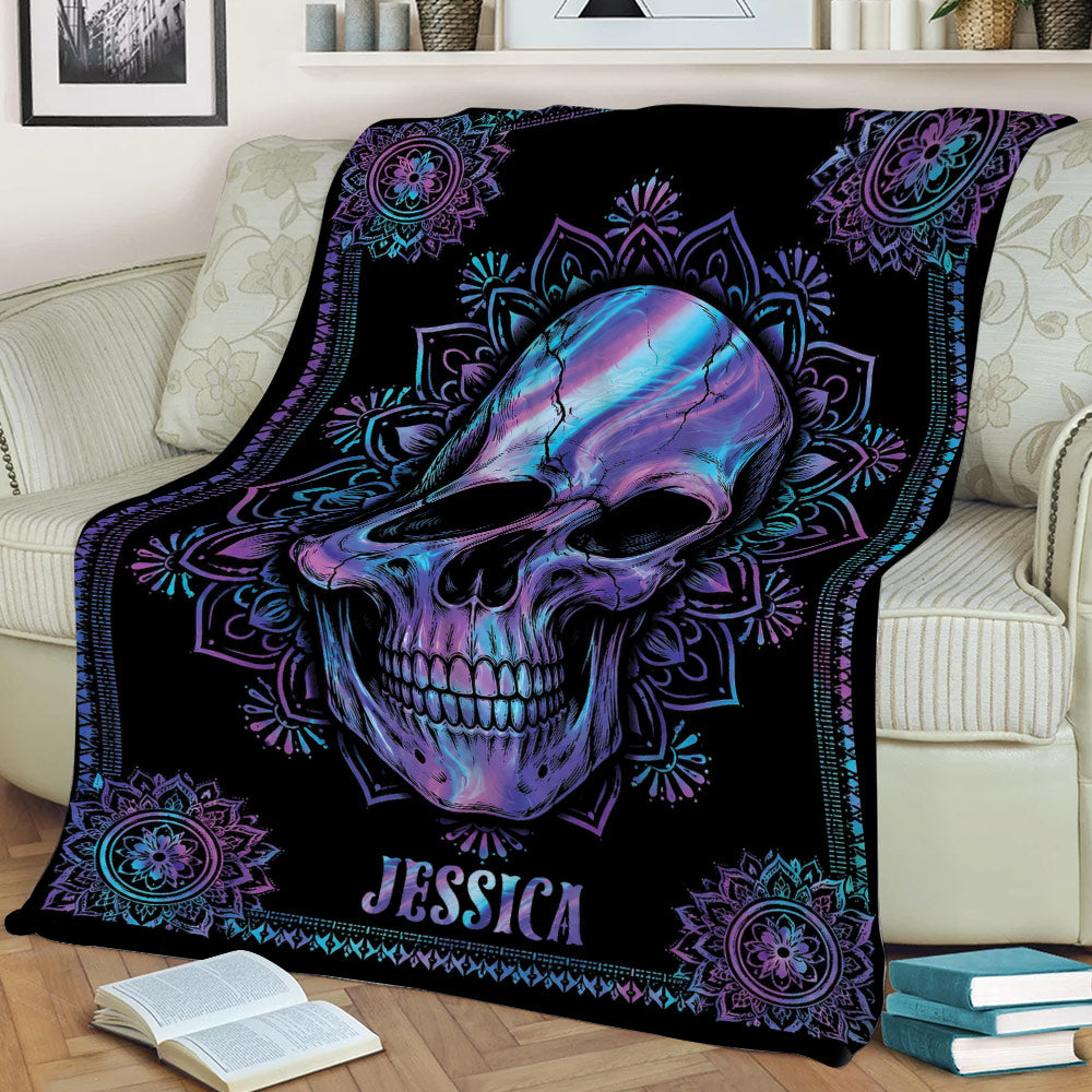 Decorative skull blanket featuring vibrant blue and purple artwork styled across a sofa
