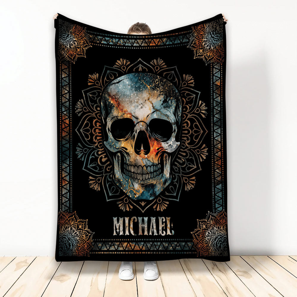 Ornate skull throw blanket with black background, blue and orange artwork, and mandala-inspired border