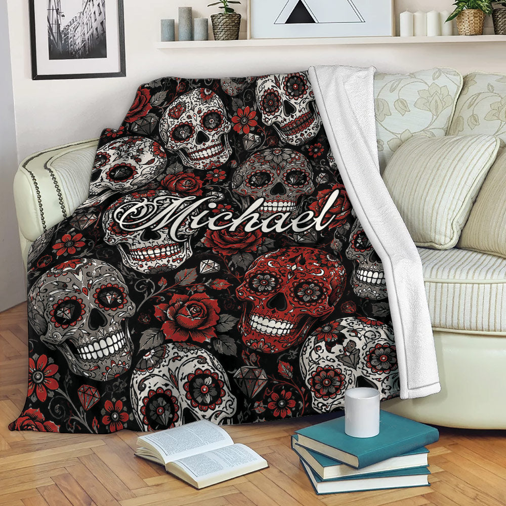 Skull blanket draped over a sofa with red roses, sugar skulls, and dark gothic artwork
