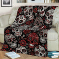 Gothic skull throw blanket displayed on a sofa with floral sugar skull artwork in black, red, and gray