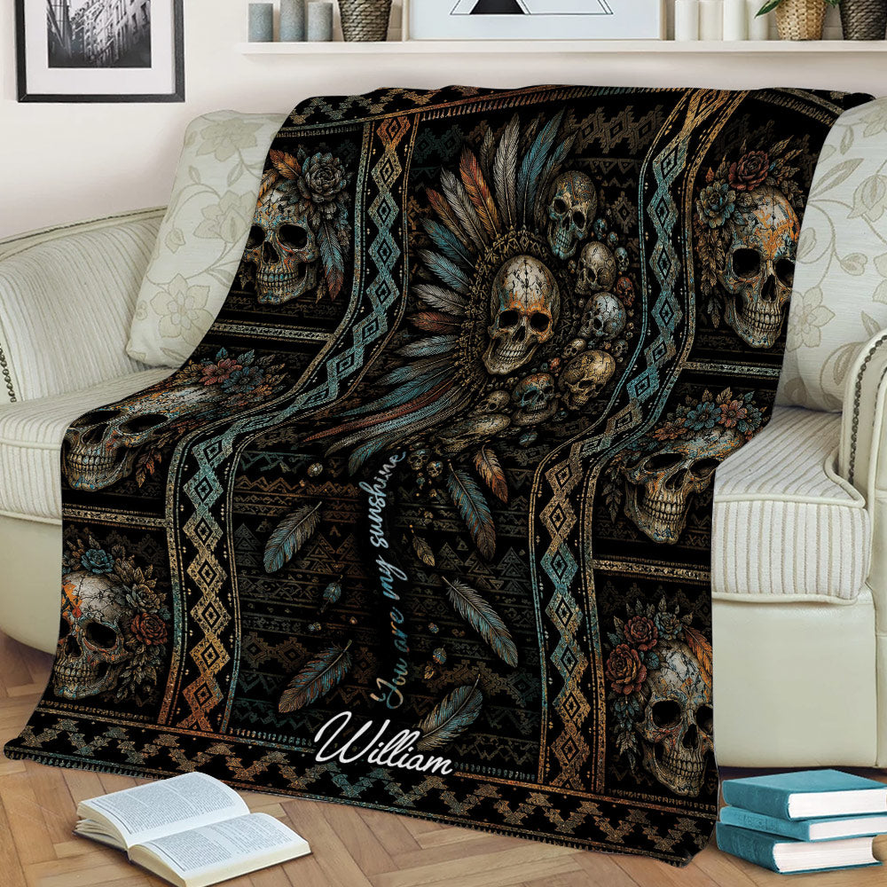 Decorative skull throw blanket displayed on a couch with feathers, flowers, and patterned borders