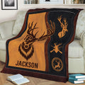 Rustic hunting throw blanket draped over a sofa with stylized deer and outdoor artwork