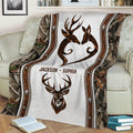 Rustic deer hunting blanket draped over a sofa, featuring a deer heart design, buck artwork, and camouflage print