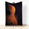Guitar throw blanket displayed upright with a detailed acoustic guitar design in warm brown and black