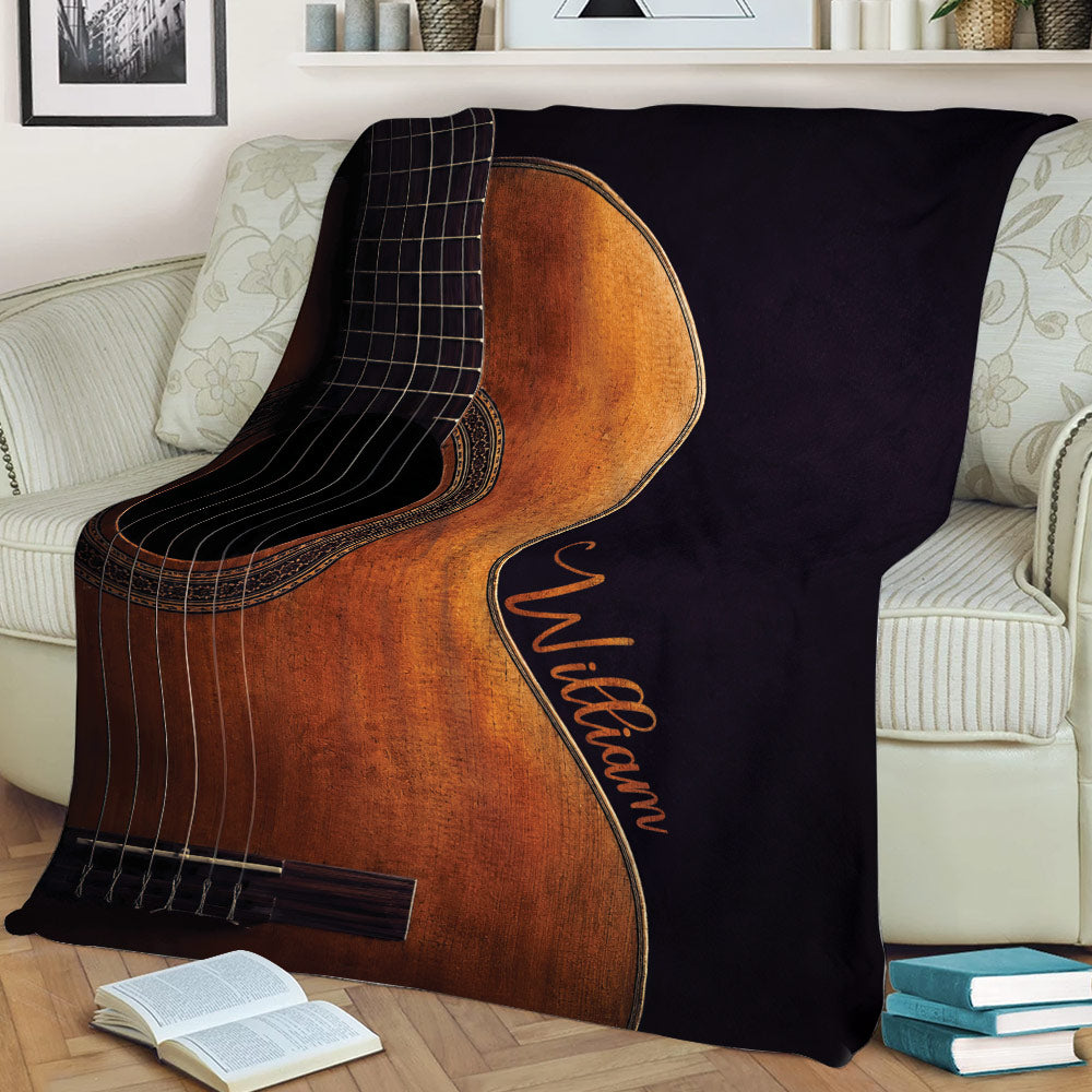 Large guitar blanket spread across a sofa with detailed strings, wood grain and dark contrasting artwork