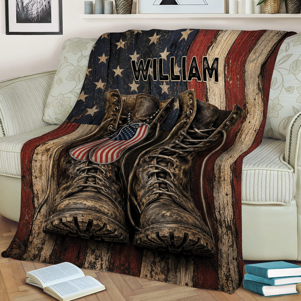 Military service themed throw blanket draped over a sofa with boots, dog tags, and American flag colors