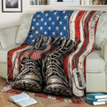 Veteran-themed throw blanket draped over a sofa with patriotic boots, flag stripes, and dog tags