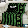 Irish throw blanket styled on a sofa with bold green stripes and repeating shamrock artwork