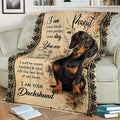 Dachshund throw blanket styled on a couch, featuring expressive black and tan wiener dog artwork