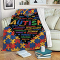 Colorful Autism throw blanket displayed on a sofa with puzzle-piece artwork and a bold black center design