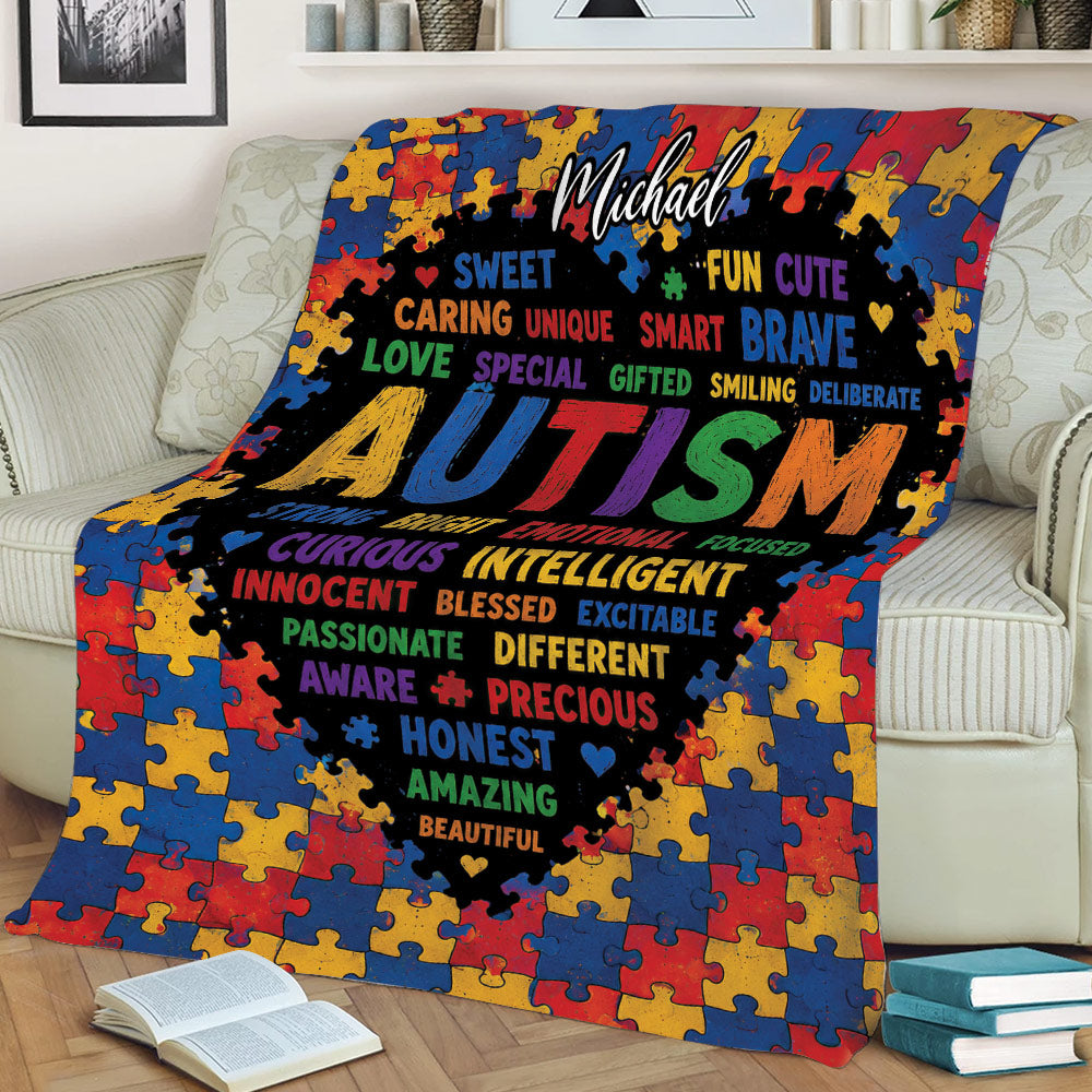 Autism blanket draped over a couch, featuring vibrant puzzle pieces, hearts, and positive uplifting words