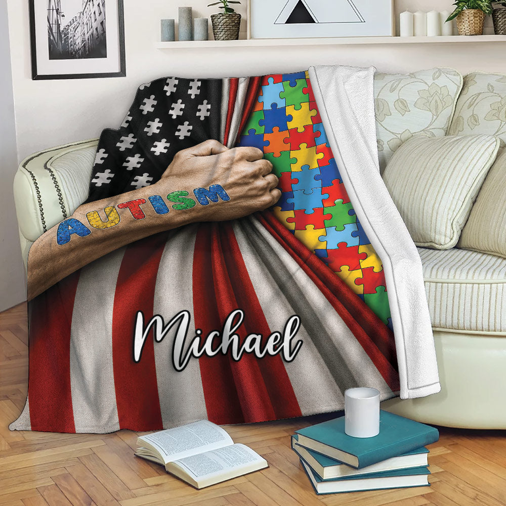 Autism blanket displayed on a sofa with colorful puzzle pieces and striking red, black, and white awareness artwork