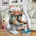 Cowboy throw blanket with Western boots and floral artwork draped over a living room sofa