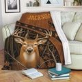 Deer hunting throw blanket draped over a sofa, showing woodland buck artwork in a cozy living room