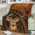 Rustic hunting blanket displayed on a sofa with a realistic buck, forest branches, and brown outdoor artwork