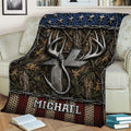 Rustic fishing blanket draped over a sofa with hook and antler artwork, woodland textures, and bold blue accents