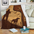 Hunting blanket draped over a sofa with a hunter, bird silhouettes, hunting dog, deer emblem, and rustic brown design