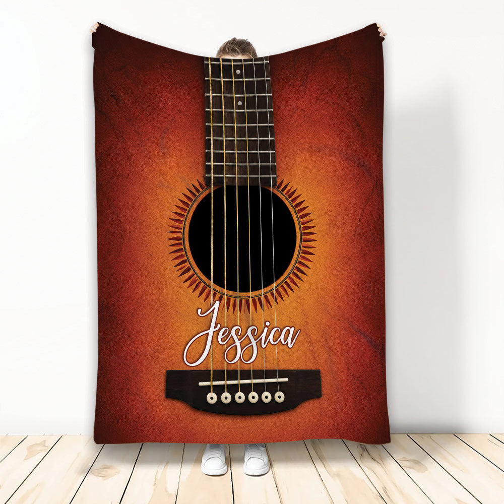 Guitar throw blanket displayed upright with a warm wood-tone acoustic guitar design