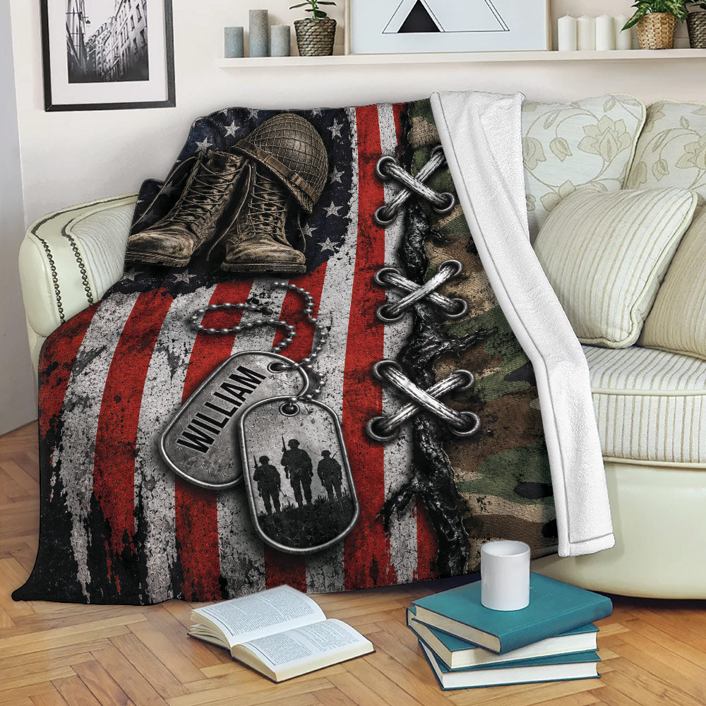 Patriotic veteran blanket displayed on a sofa with military boots, dog tags, camouflage, and flag artwork