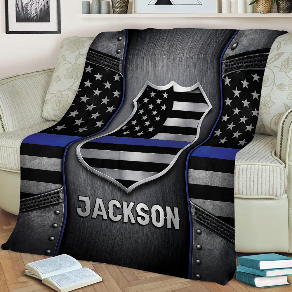 Police blanket draped over a sofa featuring a metallic shield, stars, and thin blue line design