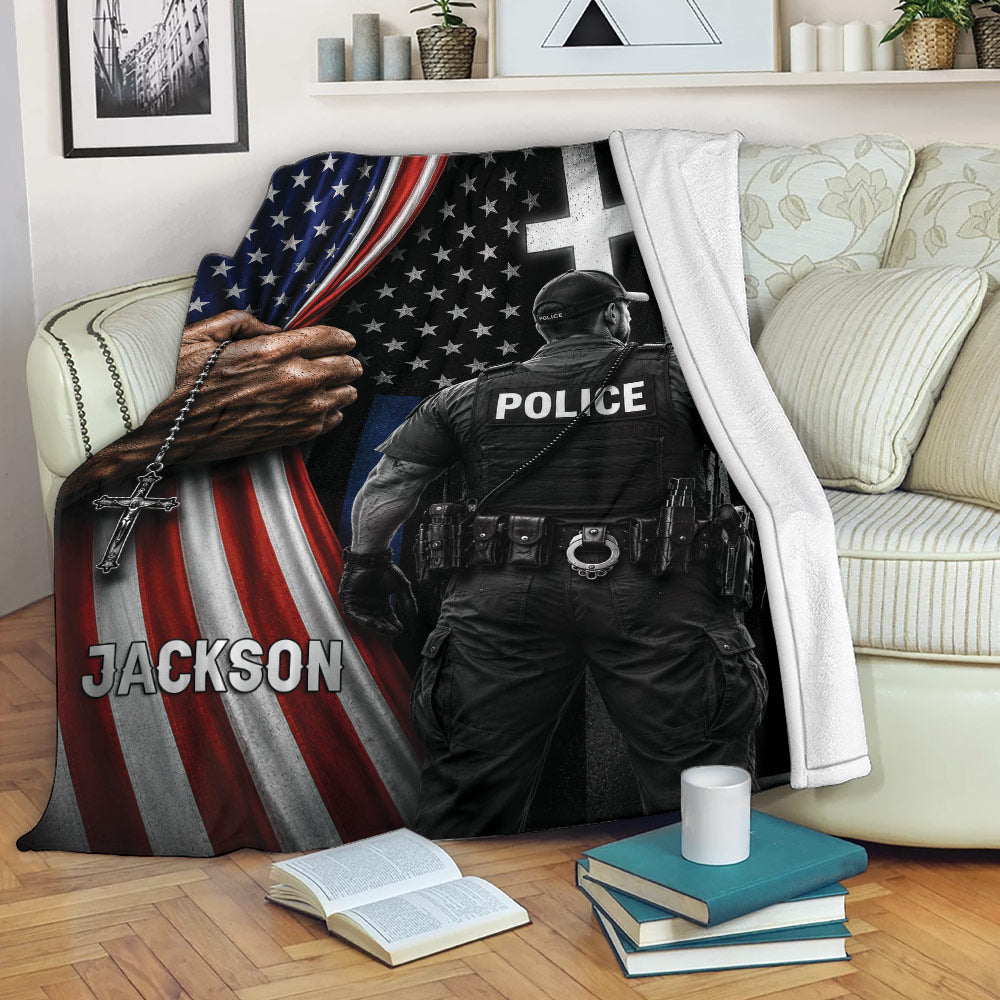 Patriotic police throw blanket draped over a couch with an officer design, American flag details, and cross