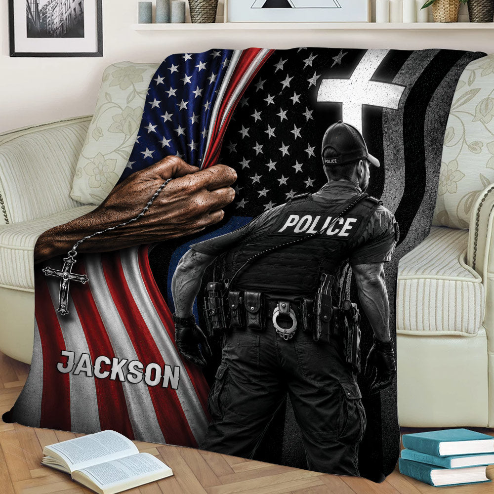 Police officer throw blanket displayed on a sofa with bold black, red, white, and blue patriotic artwork