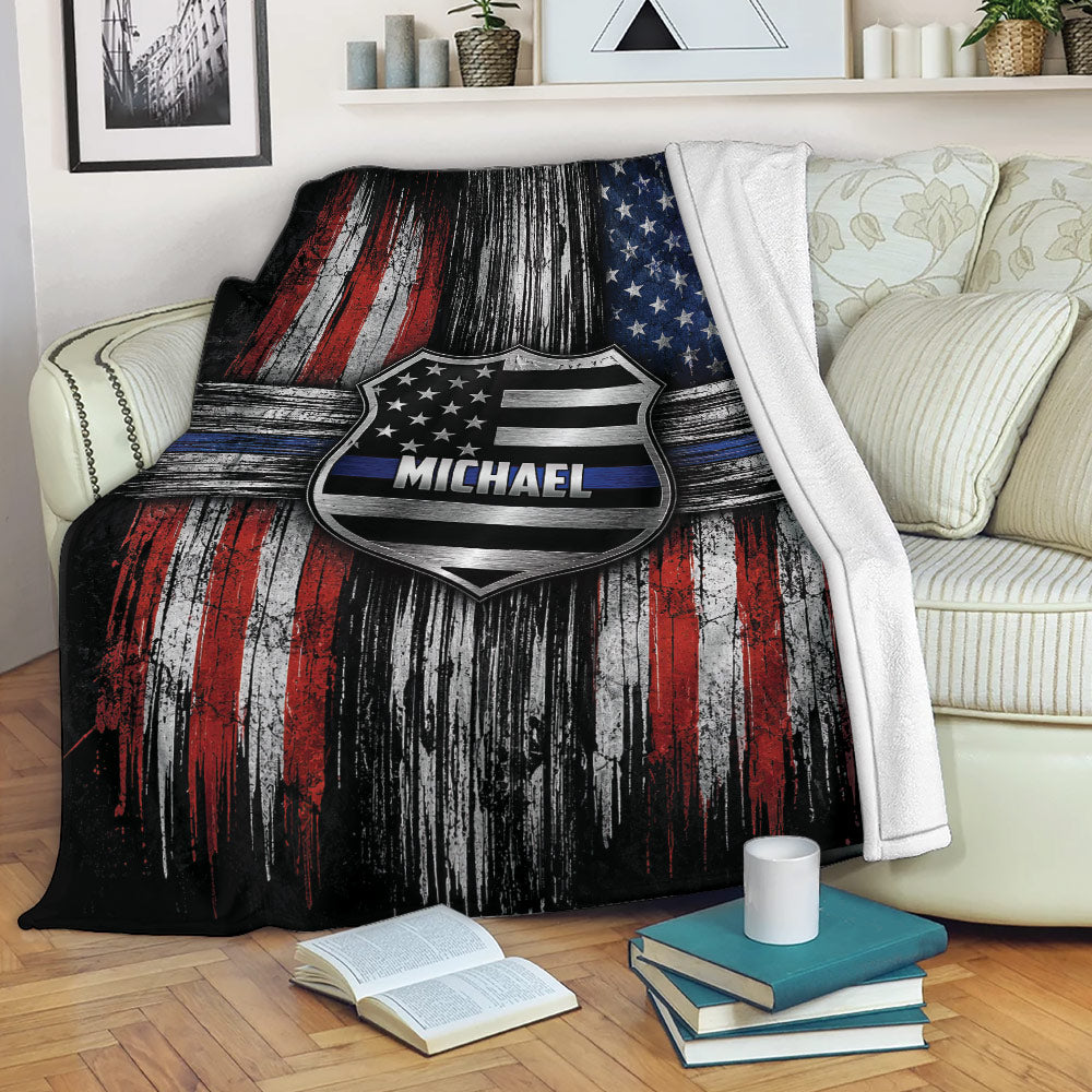 Police badge throw blanket displayed on a sofa with distressed red, white, blue, and black artwork