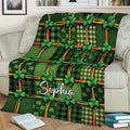Green Irish throw blanket with shamrock and plaid artwork styled on a sofa