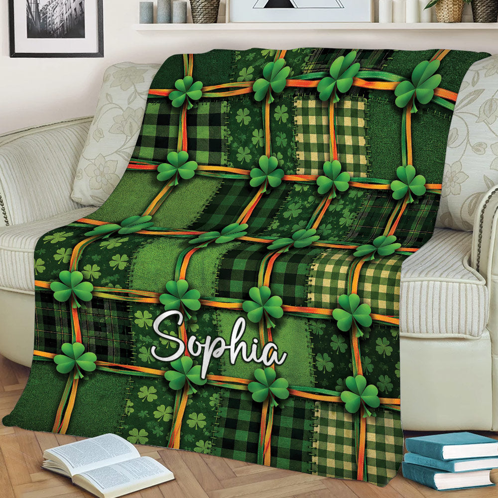 Green Irish throw blanket with shamrock and plaid artwork styled on a sofa