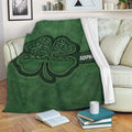Irish shamrock throw blanket with ornate green artwork draped over a living room sofa