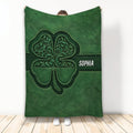 Green Irish shamrock throw blanket with ornate Celtic-inspired artwork displayed as a cozy wrap