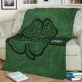 Detailed green shamrock blanket spread across a sofa with ornate Irish-inspired artwork